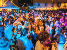 Persone danzano e ascoltano musica nel centro storico del paese all'aperto