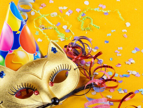 L'immagine mostra una maschera di carnevale, un cappellino e dei coriandoli