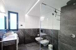 Bagno con doccia in cristallo e lavatrice